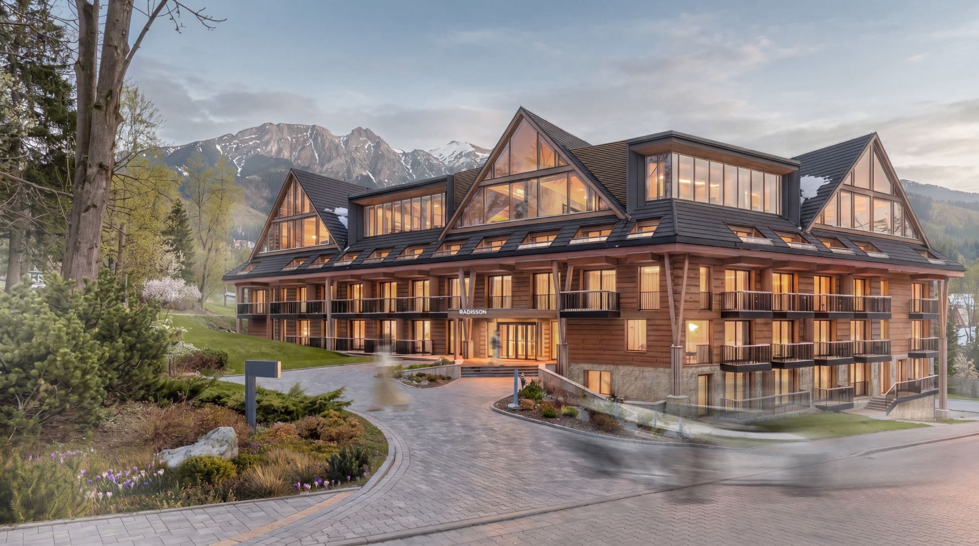 Radisson Blu Zakopane — elewacja hotelu Radisson Collection o zmierzchu z widokiem na Tatry